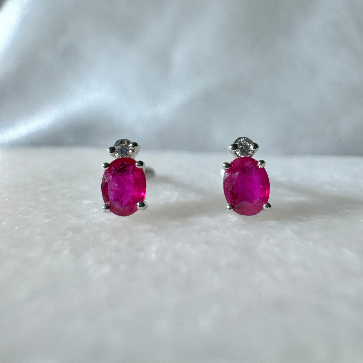 Genuine Ruby and Moving Diamond Oval Stud Earrings in 18k White Gold