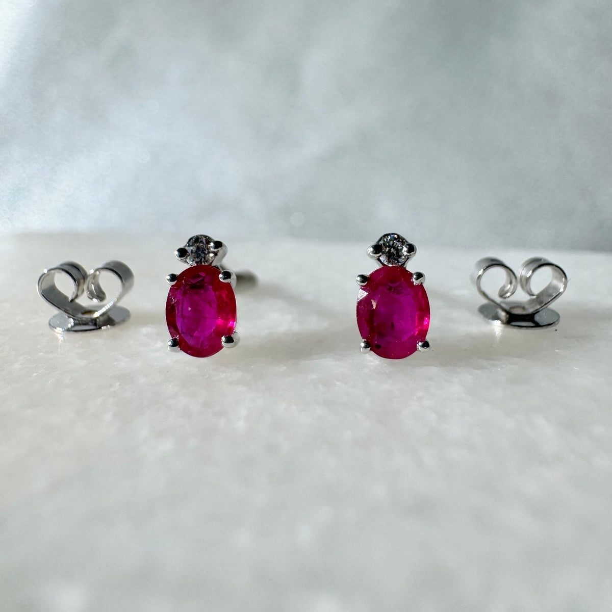 Genuine Ruby and Moving Diamond Oval Stud Earrings in 18k White Gold