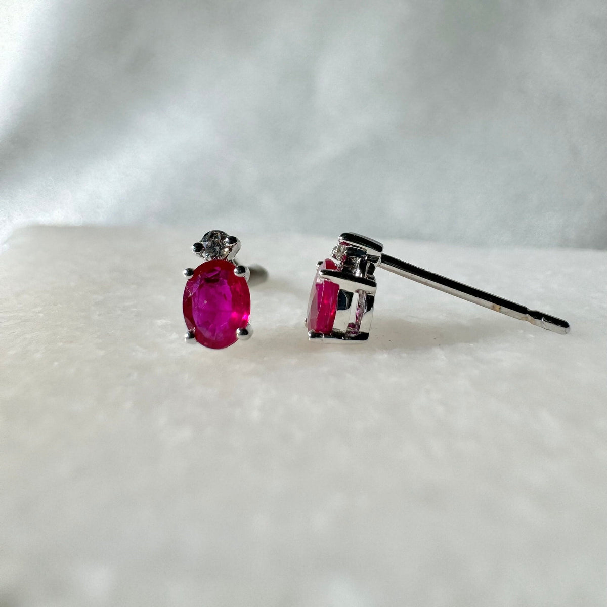 Genuine Ruby and Moving Diamond Oval Stud Earrings in 18k White Gold
